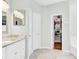 Bathroom with marble countertops, white cabinets, a mirror, and open closet at 5406 Dwight Dr, North Charleston, SC 29420