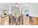 Bright dining area features hardwood floors, a modern light fixture, and an adjacent living room with fireplace at 5406 Dwight Dr, North Charleston, SC 29420