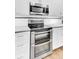 Close-up of a stainless steel double oven and microwave, with white cabinets, countertops, and a tiled backsplash at 5406 Dwight Dr, North Charleston, SC 29420