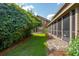Expansive backyard features lush greenery and stone path leading to a screened in porch at 5511 Colonial Chatsworth Cir, North Charleston, SC 29418