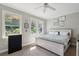 Bright bedroom with a large bed, dark dresser, and two bright windows at 5511 Colonial Chatsworth Cir, North Charleston, SC 29418