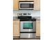 Close-up of a stainless steel oven and microwave with light wood cabinets at 5511 Colonial Chatsworth Cir, North Charleston, SC 29418