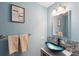 Stylish powder room with modern blue vessel sink and decorative mirror at 5511 Colonial Chatsworth Cir, North Charleston, SC 29418