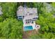 Aerial view showcasing the home, pool, outdoor seating, and fire pit surrounded by lush trees at 627 Barbados Dr, Charleston, SC 29492