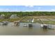 Aerial view of the dock with a covered seating area, walkways through the marsh, and a home on the water at 627 Barbados Dr, Charleston, SC 29492