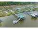 Aerial view of a private dock with covered seating area and walkways through the marshy landscape at 627 Barbados Dr, Charleston, SC 29492