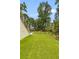 Expansive backyard with green lawn, landscaping, and partial views of the water in the distance at 627 Barbados Dr, Charleston, SC 29492