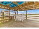 Covered boat dock featuring a dining table and seating area, overlooking the tranquil water at 627 Barbados Dr, Charleston, SC 29492