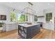 Open kitchen boasts a central island with a sink, ample counter space, and stylish lighting fixtures at 627 Barbados Dr, Charleston, SC 29492