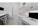 Well-lit laundry room with white cabinets, a sink, and a sleek washer/dryer at 627 Barbados Dr, Charleston, SC 29492