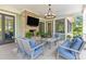 Inviting covered outdoor living area with brick fireplace, television, and comfortable seating at 627 Barbados Dr, Charleston, SC 29492