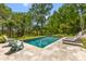 Beautiful backyard pool with travertine tile, lounge chairs and shade trees at 627 Barbados Dr, Charleston, SC 29492