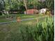 Large backyard featuring a fire pit, storage container, and covered patio area at 7274 Commodore Rd, Hollywood, SC 29449