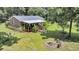 Aerial view showcasing the backyard with well-maintained lawn, fire pit, and covered deck, enhancing outdoor living at 7274 Commodore Rd, Hollywood, SC 29449