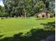 Expansive backyard with manicured lawn, brick home, and mature trees at 7274 Commodore Rd, Hollywood, SC 29449