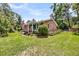 Charming brick home with manicured landscaping, complemented by inviting front porch with patriotic decorations at 7274 Commodore Rd, Hollywood, SC 29449