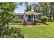 Welcoming brick home with tidy front yard, showcasing blue shutters and a patriotic welcome sign at 7274 Commodore Rd, Hollywood, SC 29449