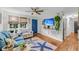 Bright living room with beach theme rug, ceiling fan, and a wall-mounted tv displaying a beach at 7274 Commodore Rd, Hollywood, SC 29449