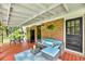 Covered patio with outdoor seating, brick accents, and a cozy atmosphere for relaxation at 7274 Commodore Rd, Hollywood, SC 29449