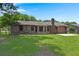 Brick house featuring a spacious backyard with a lush green lawn and mature trees at 8116 Long Shadow Ln, North Charleston, SC 29406