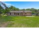 Backyard featuring a manicured lawn and brick house, perfect for outdoor enjoyment at 8116 Long Shadow Ln, North Charleston, SC 29406