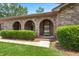 Close up of the front door with arched brick entryway and well-manicured shrubbery at 8116 Long Shadow Ln, North Charleston, SC 29406