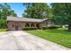 Well-maintained brick home with a spacious driveway, lush green lawn, and attached garage at 8116 Long Shadow Ln, North Charleston, SC 29406