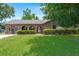 Charming single-story brick home with arched entryway, lush green lawn, and well-maintained landscaping at 8116 Long Shadow Ln, North Charleston, SC 29406