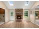 Living room featuring a brick fireplace, skylights, wood flooring, and neutral paint at 8116 Long Shadow Ln, North Charleston, SC 29406