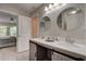 Stylish bathroom with double sinks, modern lighting, and an open doorway to an adjacent bedroom at 8483 Yadkin Cir # D, North Charleston, SC 29406