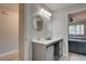 Modern bathroom featuring double sinks, gray cabinets, round mirrors, and an open door to a bedroom at 8483 Yadkin Cir # D, North Charleston, SC 29406