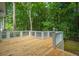 Large wooden deck featuring white railings and a peaceful wooded view for relaxing and entertaining at 9175 Spring Branch Ct, North Charleston, SC 29406