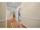 Hallway with hardwood floors leading to a living space with a fireplace and stainless steel refrigerator at 9175 Spring Branch Ct, North Charleston, SC 29406