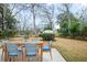 Outdoor dining set with blue cushions sits on a stone patio in the landscaped backyard at 1043 Dominion Dr, Hanahan, SC 29410
