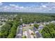 Scenic aerial view of a townhouse community surrounded by lush green forests and winding roads at 1064 Lexi Ct, Ladson, SC 29456
