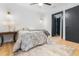 Bedroom featuring light hardwood floors, a ceiling fan, dark modern door, and a bed with patterned bedding at 1129 Dickson Ave, Hanahan, SC 29410