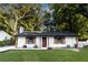 Classic updated white brick home with a dark roof, beautiful shutters, and a meticulously landscaped yard at 1129 Dickson Ave, Hanahan, SC 29410
