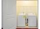 Bright laundry room with white washer and dryer, and overhead shelving for organized storage at 1184 Dingle Rd, Mount Pleasant, SC 29466