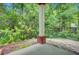 Covered patio supported by brick and painted pillars, surrounded by lush green trees and foliage at 1184 Dingle Rd, Mount Pleasant, SC 29466