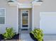 Close-up of the home's front door featuring glass, small garden area and well-manicured bushes at 123 Lagoona Dr, Summerville, SC 29483