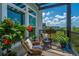 Charming balcony with seating and lovely views of blue sky, green trees, and red flowers at 125 Pier View St # 408, Charleston, SC 29492