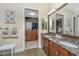 Well-lit bathroom featuring double sinks, granite countertops, and a view into a spacious walk-in closet at 125 Pier View St # 408, Charleston, SC 29492