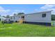 The backyard features a gray manufactured home with new wood stairs to back door at 1326 Givhans Rd, Ridgeville, SC 29472