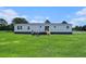 Exterior elevation view of the gray manufactured home with lawn at 1326 Givhans Rd, Ridgeville, SC 29472