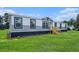 Classic manufactured home with a wood stair entrance and meticulous landscaping at 1326 Givhans Rd, Ridgeville, SC 29472
