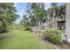 Lush backyard with green grass, mature trees, and a multi-tiered wooden deck at 134 Hummingbird Ave, Ladson, SC 29456