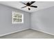 A simple bedroom features neutral walls, grey carpet, a ceiling fan, and a window with natural light at 134 Hummingbird Ave, Ladson, SC 29456