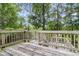 View of deck with wooden railing surrounded by green trees and open sky at 134 Hummingbird Ave, Ladson, SC 29456