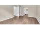 Neutral hallway with white trim, wood-look floors, and doorways to the bathroom and closet at 134 Hummingbird Ave, Ladson, SC 29456
