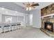 Open-concept living room features a stone fireplace, breakfast bar with stools, and a ceiling fan at 134 Hummingbird Ave, Ladson, SC 29456
